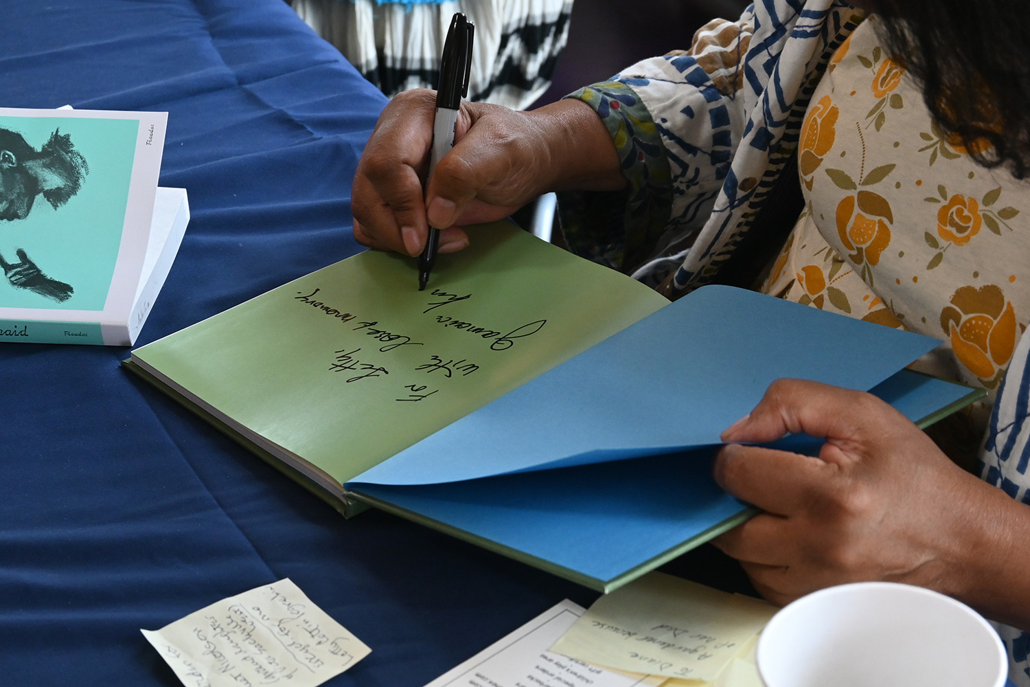 Close up of an author signing the front page of a book at the WIT Literary Festival